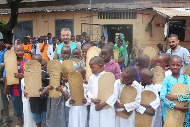 Afrika Gine'de kurstaki öğrenciler tahta levhalarda Kur'an öğreniyor